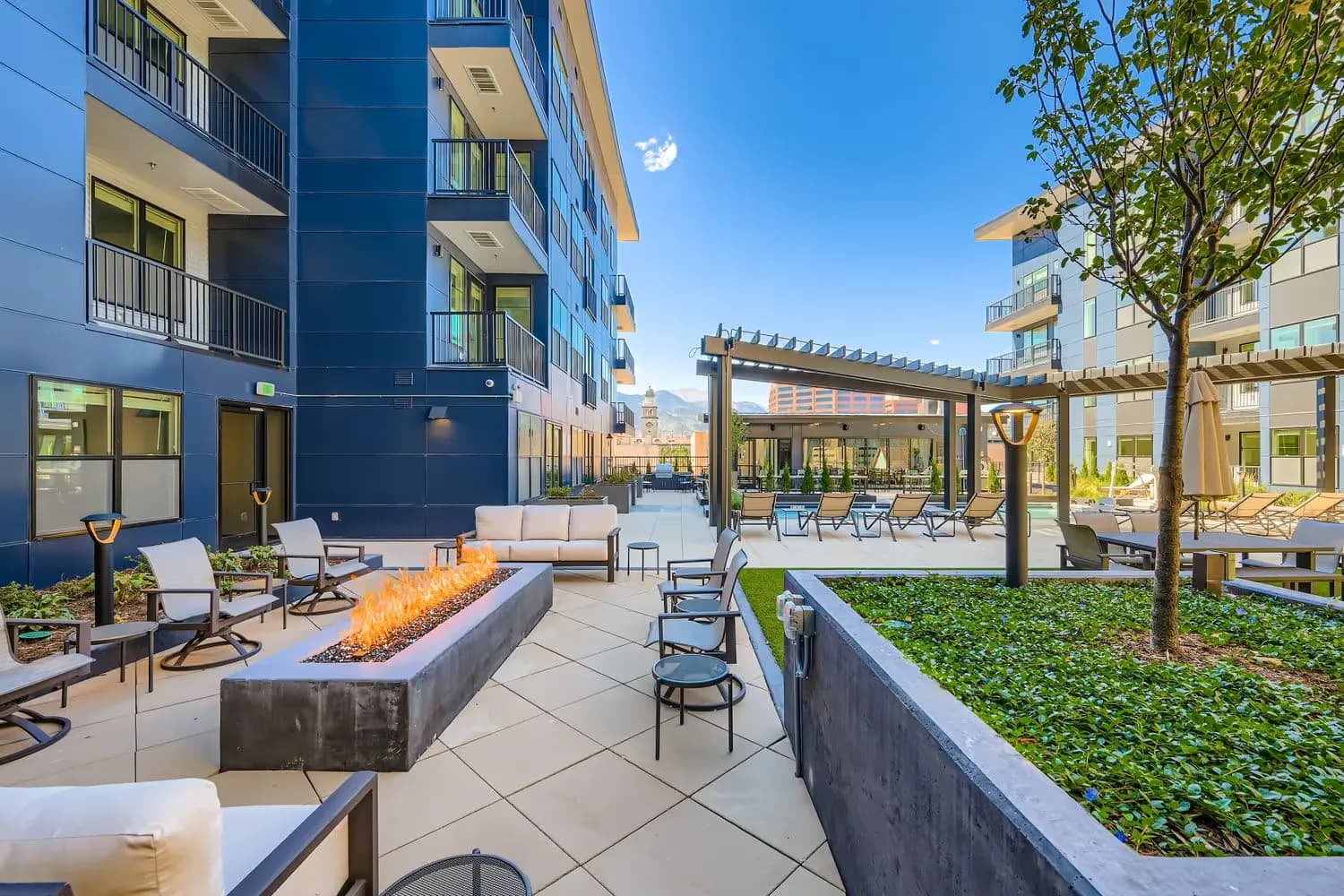 Outdoor resident fire pit lounge and social space with modern seating at Avian Apartments.