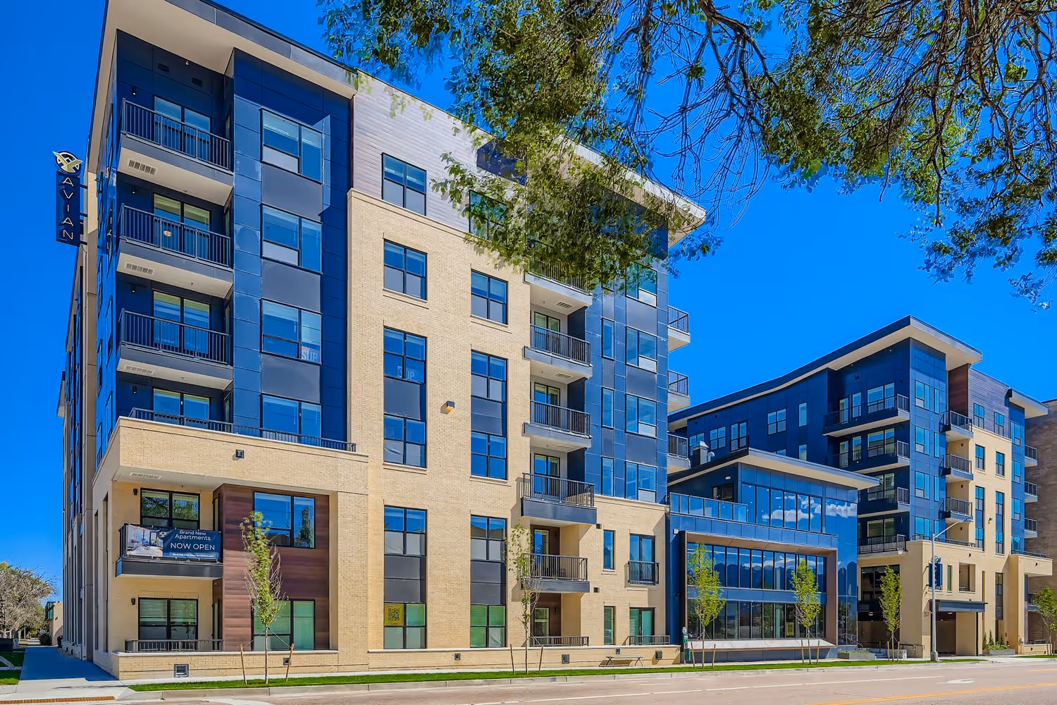 Avian Apartments exterior, showing the modern facade and ground-level entry at dusk in downtown Colorado Springs, CO.
